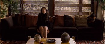 Movie still from “I'm Not There” (2007), directed by Todd Haynes – A woman sitting on a couch in front of a coffee table with vases; Medium shot, High angle