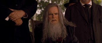 Movie still from “I'm Not There” (2007), directed by Todd Haynes – An old man with long grey hair and a long beard; Close Up shot, Over the shoulder angle