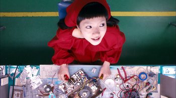 Movie still from “I'm a Cyborg, But That's OK” (2006), directed by Park Chan-wook – A young girl in a red dress is holding a pair of tools; Close Up shot, Overhead angle