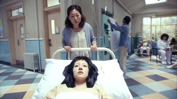 Movie still from “I'm a Cyborg, But That's OK” (2006), directed by Park Chan-wook – A young girl is lying in a hospital bed; Medium shot, High angle