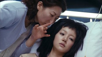 Movie still from “I'm a Cyborg, But That's OK” (2006), directed by Park Chan-wook – A woman is touching the face of a woman; Close Up shot, Over the shoulder angle