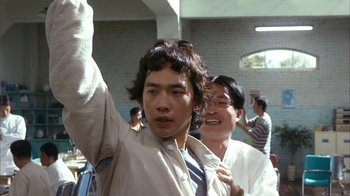 Movie still from “I'm a Cyborg, But That's OK” (2006), directed by Park Chan-wook – A man in a tie is waving at the camera; Close Up shot, Low angle