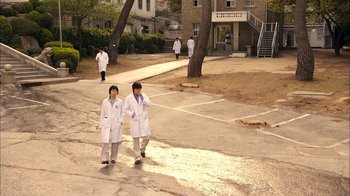 Movie still from “I'm a Cyborg, But That's OK” (2006), directed by Park Chan-wook – A couple of people in lab coats walking down a street; Extreme Wide shot, Low angle