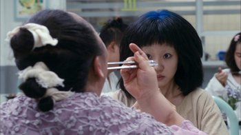 Movie still from “I'm a Cyborg, But That's OK” (2006), directed by Park Chan-wook – A woman holding chopsticks in front of another woman; Close Up shot, Over the shoulder angle