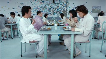 Movie still from “I'm a Cyborg, But That's OK” (2006), directed by Park Chan-wook – A group of people sitting around a table eating food; Wide shot, High angle