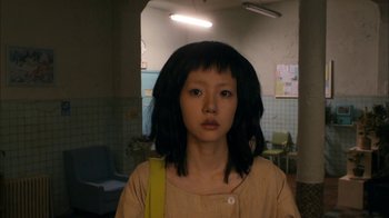 Movie still from “I'm a Cyborg, But That's OK” (2006), directed by Park Chan-wook – A young woman with black hair wearing a yellow bag; Close Up shot, High angle
