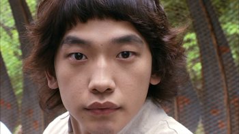 Movie still from “I'm a Cyborg, But That's OK” (2006), directed by Park Chan-wook – A person's face with a tree in the background; Close Up shot, Low angle