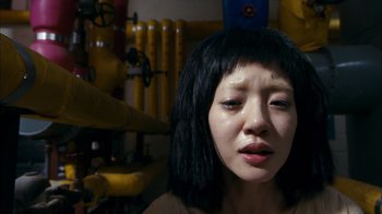 Movie still from “I'm a Cyborg, But That's OK” (2006), directed by Park Chan-wook – A young woman with black hair is looking at the camera; Close Up shot, Overhead angle