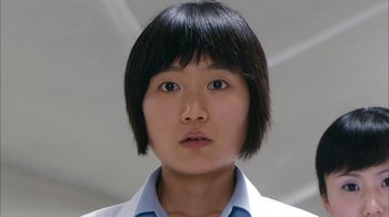 Movie still from “I'm a Cyborg, But That's OK” (2006), directed by Park Chan-wook – A young woman with short black hair wearing a white shirt; Close Up shot, Low angle