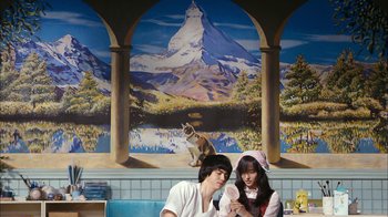 Movie still from “I'm a Cyborg, But That's OK” (2006), directed by Park Chan-wook – A man and a woman sitting in front of a painting; Wide shot, Low angle