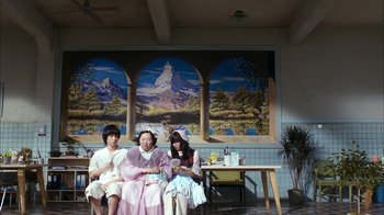 Movie still from “I'm a Cyborg, But That's OK” (2006), directed by Park Chan-wook – A group of women sitting on a bench in front of a painting; Wide shot, Low angle