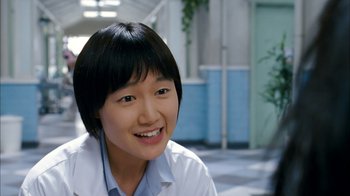Movie still from “I'm a Cyborg, But That's OK” (2006), directed by Park Chan-wook – A young asian woman smiling for the camera; Close Up shot, Over the shoulder angle