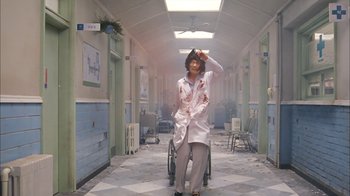 Movie still from “I'm a Cyborg, But That's OK” (2006), directed by Park Chan-wook – A person in a wheelchair in a hospital hallway; Wide shot, Low angle