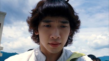 Movie still from “I'm a Cyborg, But That's OK” (2006), directed by Park Chan-wook – A young man with long black hair wearing a white shirt; Close Up shot, Low angle
