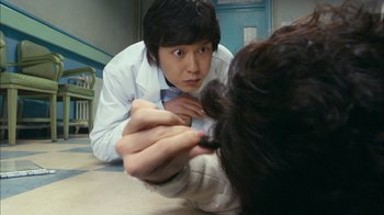 Movie still from “I'm a Cyborg, But That's OK” (2006), directed by Park Chan-wook – A man in a white lab coat looking at a woman's hair; Close Up shot, Over the shoulder angle