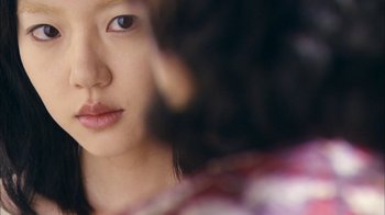 Movie still from “I'm a Cyborg, But That's OK” (2006), directed by Park Chan-wook – A young woman's face; Extreme Close Up shot, Over the shoulder angle