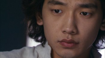 Movie still from “I'm a Cyborg, But That's OK” (2006), directed by Park Chan-wook – A young man's face with long black hair; Close Up shot, High angle