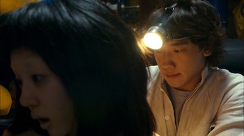 Movie still from “I'm a Cyborg, But That's OK” (2006), directed by Park Chan-wook – A man with a head lamp on his head; Close Up shot, Over the shoulder angle