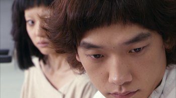 Movie still from “I'm a Cyborg, But That's OK” (2006), directed by Park Chan-wook – A young man's face with another man in the background; Extreme Close Up shot, High angle