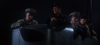 Movie still from “Ice Station Zebra” (1968), directed by John Sturges – A group of men standing next to each other on a bridge; Medium shot, Low angle