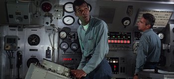 Movie still from “Ice Station Zebra” (1968), directed by John Sturges – A man standing in front of a control panel; Medium shot, High angle