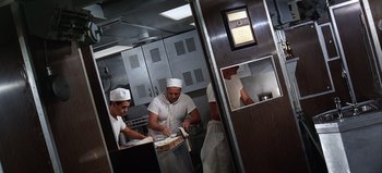 Movie still from “Ice Station Zebra” (1968), directed by John Sturges – Three chefs in a kitchen preparing food; Wide shot, Low angle
