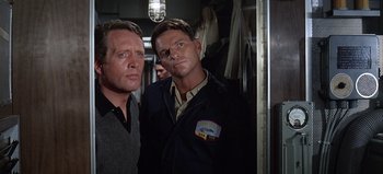 Movie still from “Ice Station Zebra” (1968), directed by John Sturges – A couple of men standing next to each other in a room; Medium shot, Low angle