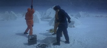 Movie still from “Ice Station Zebra” (1968), directed by John Sturges – Two people in the snow near a pile of snow; Wide shot, High angle