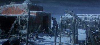 Movie still from “Ice Station Zebra” (1968), directed by John Sturges – A man standing in front of a snow covered building; Wide shot, High angle