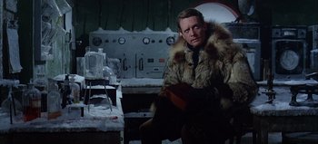 Movie still from “Ice Station Zebra” (1968), directed by John Sturges – A man wearing a fur coat sitting in a room; Medium shot, Over the shoulder angle