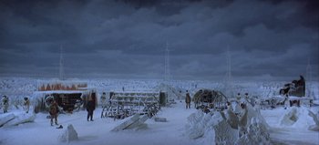 Movie still from “Ice Station Zebra” (1968), directed by John Sturges – A group of people standing in the middle of a snow covered field; Extreme Wide shot, High angle