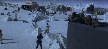 Movie still from “Ice Station Zebra” (1968), directed by John Sturges – A group of people standing in the middle of a snow covered field; Extreme Wide shot, High angle