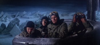 Movie still from “Ice Station Zebra” (1968), directed by John Sturges – A group of men sitting on top of a hill; Medium shot, High angle