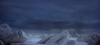 Movie still from “Ice Station Zebra” (1968), directed by John Sturges – A dark cloudy sky over a snowy landscape; Extreme Wide shot, High angle