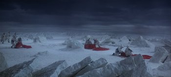 Movie still from “Ice Station Zebra” (1968), directed by John Sturges – A group of people sitting in the middle of a snow covered field; Extreme Wide shot, High angle