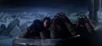 Movie still from “Ice Station Zebra” (1968), directed by John Sturges – A group of people looking through binoculars at night; Medium shot, Low angle