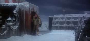Movie still from “Ice Station Zebra” (1968), directed by John Sturges – A man standing in front of an ice house; Wide shot, High angle