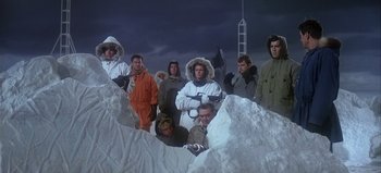 Movie still from “Ice Station Zebra” (1968), directed by John Sturges – A group of people standing in the middle of a snowy field; Wide shot, Low angle