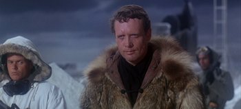 Movie still from “Ice Station Zebra” (1968), directed by John Sturges – A man wearing a fur coat and a black shirt; Close Up shot, Over the shoulder angle