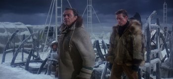 Movie still from “Ice Station Zebra” (1968), directed by John Sturges – A man in a fur coat standing next to another man in a fur coat; Medium shot, Over the shoulder angle