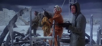 Movie still from “Ice Station Zebra” (1968), directed by John Sturges – A group of people standing in the middle of a snowy field; Medium shot, Low angle