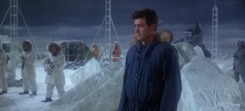 Movie still from “Ice Station Zebra” (1968), directed by John Sturges – A man standing in the middle of a snow covered field; Medium shot, Over the shoulder angle