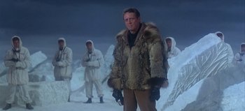 Movie still from “Ice Station Zebra” (1968), directed by John Sturges – A man in a fur coat standing in the middle of a snowy field; Medium shot, Low angle