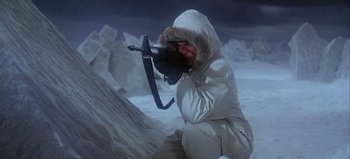 Movie still from “Ice Station Zebra” (1968), directed by John Sturges – A man in a white jacket is holding a gun; Medium shot, High angle