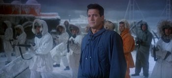 Movie still from “Ice Station Zebra” (1968), directed by John Sturges – A group of people in white suits and a man in a blue jacket; Medium shot, Low angle