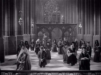 Movie still from “If I Were King” (1938), directed by Frank Lloyd – A black and white photo of people sitting in a church; Extreme Wide shot, High angle