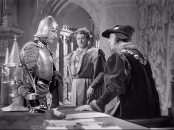 Movie still from “If I Were King” (1938), directed by Frank Lloyd – A group of men standing next to each other in a room; Medium shot, Over the shoulder angle