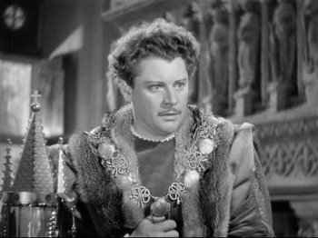 Movie still from “If I Were King” (1938), directed by Frank Lloyd – A black and white photo of a man wearing a crown; Close Up shot, Over the shoulder angle