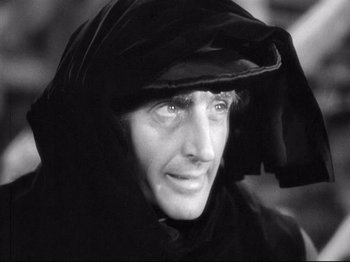 Movie still from “If I Were King” (1938), directed by Frank Lloyd – A person wearing a hood; Close Up shot, Over the shoulder angle
