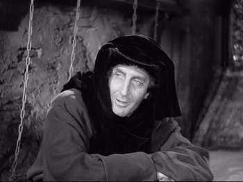 Movie still from “If I Were King” (1938), directed by Frank Lloyd – An old man wearing a black robe and a black hat; Close Up shot, Over the shoulder angle
